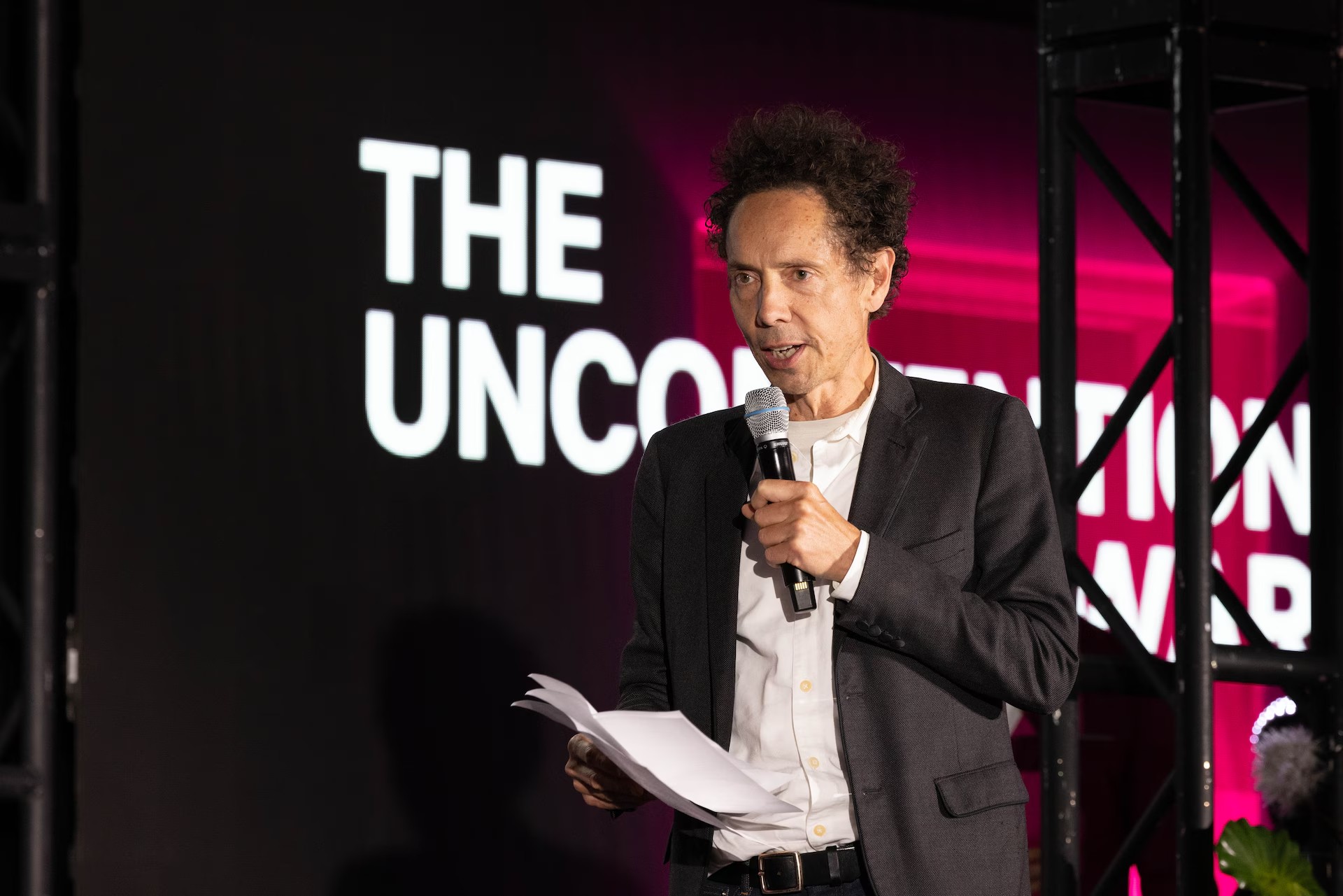 Graphic of a typography specimen showing the alphabet and numerals on top of a dark gray background.